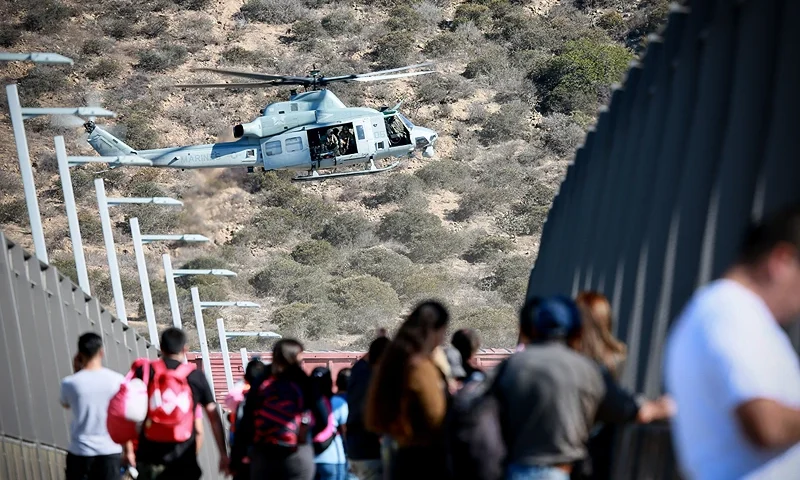 A United States Military helicopter flies past a pedestrian bridge after the closing of the United States-Mexico border was ordered on November 25, 2018 at the San Ysidro border crossing point south of San Diego, California. - US officials closed a border crossing in southern California on Sunday after hundreds of migrants tried to breach a border fence from the Mexican city of Tijuana, US authorities announced. The US Customs and Border Protection office in San Diego, California, said on Twitter that it had closed both north and south access to vehicle traffic at the San Ysidro border post, before also suspending pedestrian crossings. (Photo by Sandy Huffaker / AFP) (Photo credit should read SANDY HUFFAKER/AFP via Getty Images)