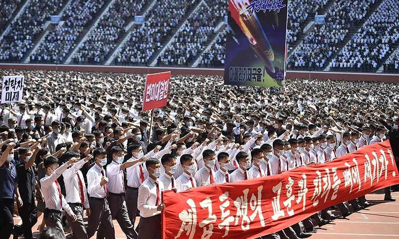 In this photo taken on June 25, 2023, residents of Pyongyang hold a banner that reads "Let us bear deep in mind the lesson and truth of class struggle!" during a mass rally to mark the "Day of Struggle Against US Imperialism", on the 73rd anniversary of the three-year Korean War, which began on June 25, 1950, at the Mayday Stadium in Pyongyang. (Photo by KIM Won Jin / AFP) (Photo by KIM WON JIN/AFP via Getty Images)