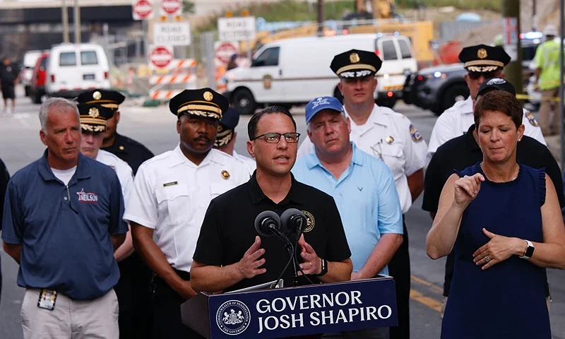 Pennsylvania Governor Josh Shapiro speaks to members of the media near a collapsed portion of Interstate 95, caused by a large vehicle fire, in Philadelphia, Pennsylvania, on June 11, 2023. A fire caused part of a busy US highway overpass to collapse in Philadelphia early Sunday, authorities said, as reports attributed the accident to an oil tanker that burst into flames under the bridge. The collapse took out four traffic lanes along an elevated section of the heavily traveled motorway, though no injuries were immediately reported. (Photo by KENA BETANCUR/AFP via Getty Images)