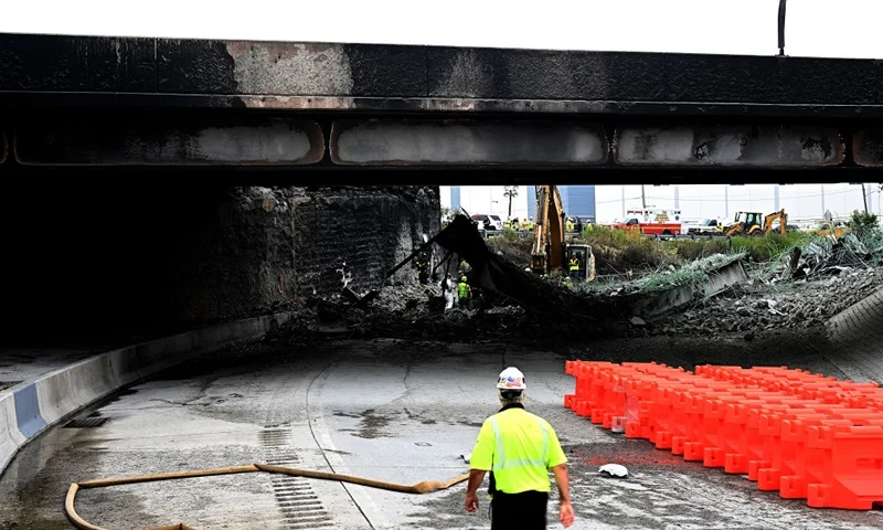 Workers inspect and clear debris from a section of the bridge that collapsed on Interstate 95 after an oil tanker explosion on June 12, 2023 in Philadelphia, Pennsylvania. Traffic was severely affected due to the closure of this primary north-to-south highway for East Coast travel. (Photo by Mark Makela/Getty Images)