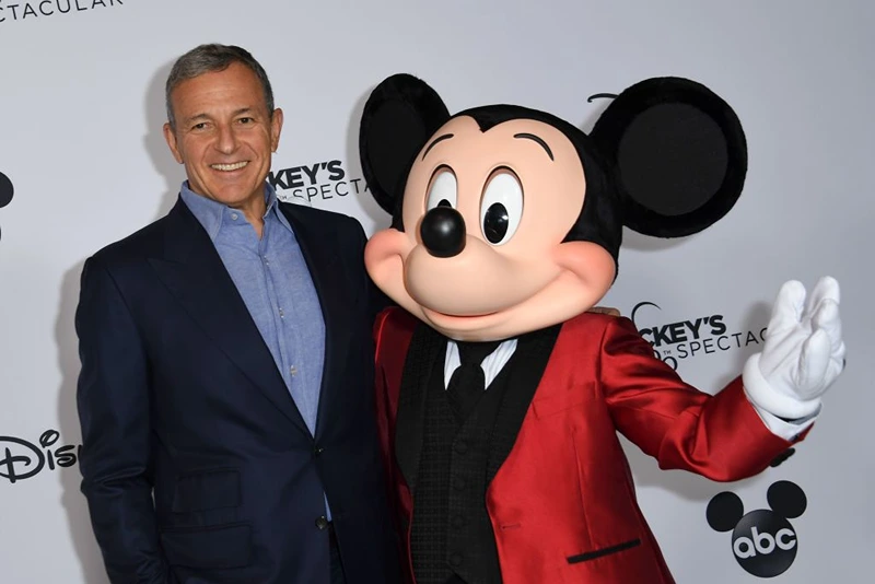 Walt Disney Company Chairman and CEO Robert A Iger poses with Mickey Mouse attends Mickey's 90th Spectacular at The Shrine Auditorium on October 6, 2018 in Los Angeles. (Photo by VALERIE MACON / AFP) (Photo credit should read VALERIE MACON/AFP via Getty Images)