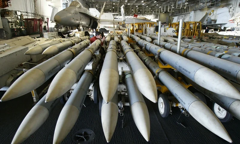 A US Navy ordnance handler sits, awaiting instructions, amid stacked AMRAAM missiles in the hangar bay of the USS Kitty Hawk 28 March 2003 in northern Gulf waters. The airwing of the Kitty Hawk is providing close air support to the US Army and the US Marine Corps in Operation Iraqi Freedom. AFP PHOTO/Leila GORCHEV (Photo by LEILA GORCHEV / AFP) (Photo by LEILA GORCHEV/AFP via Getty Images)