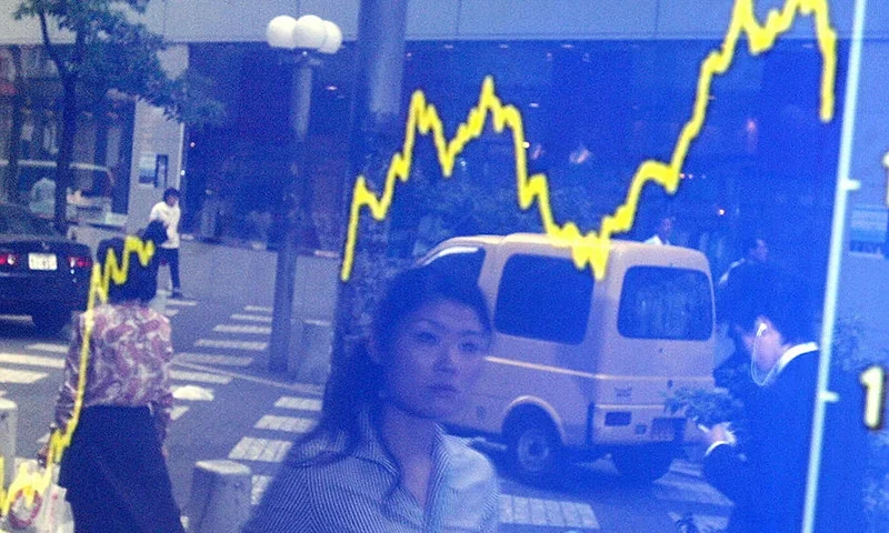 TOKYO, JAPAN: Pedestrians are reflected on a share prices chart at downtown Tokyo 19 May 2005. Japanese share prices rose 241.75 points to close at 11,077.16 points at the Tokyo STock Exchange, supported by further sharp gains on Wall Street overnight after tame US inflation figures and a drop in crude oil prices. AFP PHOTO/Yoshikazu TSUNO (Photo credit should read YOSHIKAZU TSUNO/AFP via Getty Images)