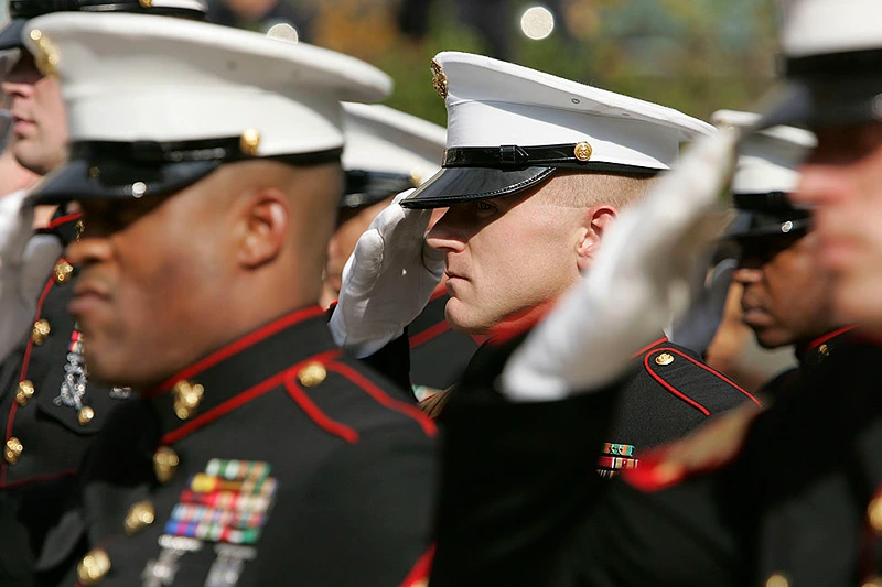 SAN FRANCISCO - NOVEMBER 10: Members of the U.S. Marine Corp honor guard salute during the singing of the National Anthem during the unveiling ceremony for the new "Distinguished Marines" commemorative stamps November 10, 2005 in San Francisco, California. The U.S. Postal Service issued a commemorative stamp series called "Distinguished Marines." on the 230th birthday of the U.S. Marine Corp. The four-stamp series features images of U.S. Marines Lewis B. Puller, Daniel J. Daly, John Basilone and John A. Lejeune. (Photo by Justin Sullivan/Getty Images)