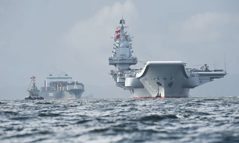 TOPSHOT - China's sole aircraft carrier, the Liaoning (R), arrives in Hong Kong waters on July 7, 2017, less than a week after a high-profile visit by president Xi Jinping. China's national defence ministry had said the Liaoning, named after a northeastern Chinese province, was part of a flotilla on a "routine training mission" and would make a port of call in the former British colony. / AFP PHOTO / Anthony WALLACE (Photo credit should read ANTHONY WALLACE/AFP via Getty Images)