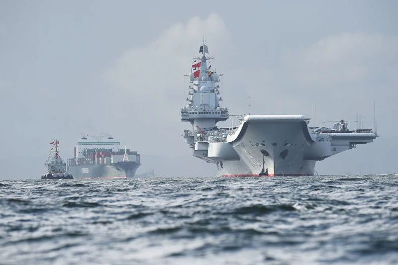 TOPSHOT - China's sole aircraft carrier, the Liaoning (R), arrives in Hong Kong waters on July 7, 2017, less than a week after a high-profile visit by president Xi Jinping. China's national defence ministry had said the Liaoning, named after a northeastern Chinese province, was part of a flotilla on a "routine training mission" and would make a port of call in the former British colony. / AFP PHOTO / Anthony WALLACE (Photo credit should read ANTHONY WALLACE/AFP via Getty Images)

