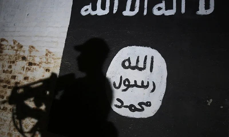 TOPSHOT - A member of the Iraqi forces walks past a mural bearing the logo of the Islamic State (IS) group in a tunnel that was reportedly used as a training centre by the jihadists, on March 1, 2017, in the village of Albu Sayf, on the southern outskirts of Mosul. Iraqi forces launched a major push on February 19 to recapture the west of Mosul from the Islamic State jihadist group, retaking the airport and then advancing north. / AFP PHOTO / AHMAD AL-RUBAYE (Photo credit should read AHMAD AL-RUBAYE/AFP via Getty Images)