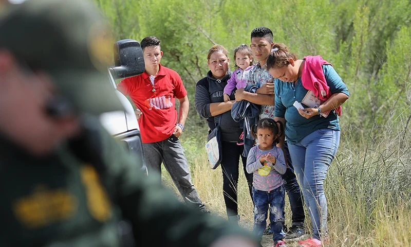 MCALLEN, TX - JUNE 12: Central American asylum seekers wait as U.S. Border Patrol agents take groups of them into custody on June 12, 2018 near McAllen, Texas. The families were then sent to a U.S. Customs and Border Protection (CBP) processing center for possible separation. U.S. border authorities are executing the Trump administration's zero tolerance policy towards undocumented immigrants. U.S. Attorney General Jeff Sessions also said that domestic and gang violence in immigrants' country of origin would no longer qualify them for political-asylum status. (Photo by John Moore/Getty Images)