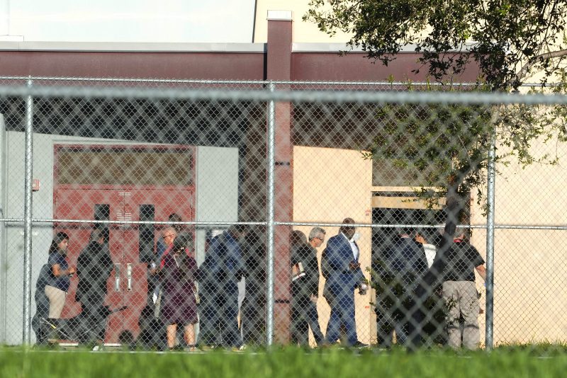 Nine members of Congress and others enter to enter Marjory Stoneman Douglas High School, Friday, Aug. 4, 2023, in Parkland, Fla. The group will tour the blood-stained and bullet-pocked halls, shortly before ballistics technicians reenact the massacre that left 14 students and three staff members dead in 2018. The reenactment is part of a lawsuit filed by the victims' families against former Deputy Scot Peterson and the Broward Sheriff's Office. (AP Photo/Marta Lavandier)