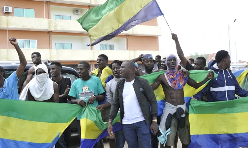 Residents holding Gabon national flags celebrate in Libreville on August 30, 2023 after a group of Gabonese military officers appeared on television announcing they were "putting an end to the current regime" and scrapping official election results that had handed another term to veteran President Ali Bongo Ondimba. In a pre-dawn address, a group of officers declared "all the institutions of the republic" had been dissolved, the election results cancelled and the borders closed. (Photo by AFP) (Photo by -/AFP via Getty Images)