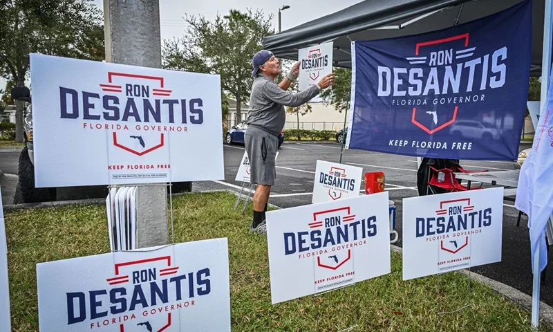 Carlos Crespo hangs signs in support of Florida State Governor Ron Desantis, outside a polling site in St Petersburg, Florida, on November 8, 2022. (Photo by Giorgio VIERA / AFP) (Photo by GIORGIO VIERA/AFP via Getty Images)