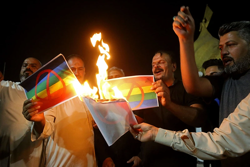 IRAQ-SWEDEN-RELIGION-KORAN
Supporters of Iraqi Shiite cleric Moqtada Sadr burn posters depicting an LGBTQ+ flag during a protest in Karbala on June 29, 2023, denouncing the burning of the Koran in Sweden. Iraqi protesters breached Sweden's embassy in Baghdad on Thursday, angered by a Koran burning outside a Stockholm mosque that sparked condemnation across the Muslim world. (Photo by Mohammed SAWAF / AFP) (Photo by MOHAMMED SAWAF/AFP via Getty Images)