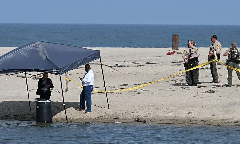 Officials stand next to a barrel where a body was discovered in Malibu Lagoon State Beach, California on July 31, 2023. A body stuffed in a barrel was discovered July 31, 2023 on Malibu Beach, a swanky Californian hotspot beloved by the rich and famous, police said. Reports said the man's corpse was crammed into a 55-gallon drum when it was discovered by maintenance workers. (Photo by Robyn Beck / AFP) (Photo by ROBYN BECK/AFP via Getty Images)
