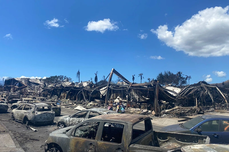 TOPSHOT - Burned cars, destroyed buildings and homes are pictured in the aftermath of a wildfire in Lahaina, western Maui, Hawaii on August 11, 2023. A wildfire that left Lahaina in charred ruins has killed at least 55 people, authorities said on August 10, making it one of the deadliest disasters in the US state's history. Brushfires on Maui, fueled by high winds from Hurricane Dora passing to the south of Hawaii, broke out August 8 and rapidly engulfed Lahaina. (Photo by Paula RAMON / AFP) / "The erroneous mention[s] appearing in the metadata of this photo by Paula RAMON has been modified in AFP systems in the following manner: [August 11] instead of [Auguat 10]. Please immediately remove the erroneous mention[s] from all your online services and delete it (them) from your servers. If you have been authorized by AFP to distribute it (them) to third parties, please ensure that the same actions are carried out by them. Failure to promptly comply with these instructions will entail liability on your part for any continued or post notification usage. Therefore we thank you very much for all your attention and prompt action. We are sorry for the inconvenience this notification may cause and remain at your disposal for any further information you may require." (Photo by PAULA RAMON/AFP via Getty Images)