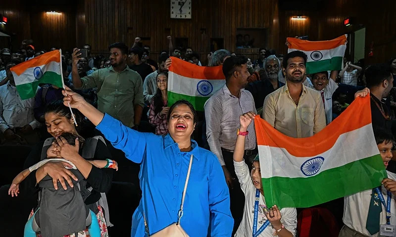 People wave India's national flag at the Nehru Science Centre in Mumbai on August 23, 2023, to celebrate the successful lunar landing of Chandrayaan-3 spacecraft on the south pole of the Moon. India on August 23, became the first nation to land a craft near the Moon's south pole, a historic triumph for the world's most populous nation and its ambitious, cut-price space programme. (Photo by Punit PARANJPE / AFP) (Photo by PUNIT PARANJPE/AFP via Getty Images)