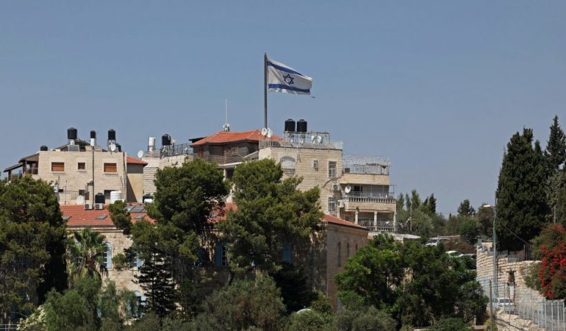 An Israeli flag flutters above a building in the mostly Arab neighbourhood of al-Tur, in east Jerusalem on August 25, 2023. (Photo by AHMAD GHARABLI / AFP) (Photo by AHMAD GHARABLI/AFP via Getty Images)