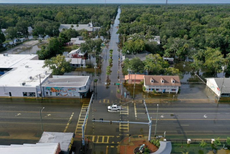 CRYSTAL RIVER, FLORIDA - AUGUST 30: In an aerial view, a vehicle drives through a flooded street in the downtown area after Hurricane Idalia passed offshore on August 30, 2023 in Crystal River, Florida. Hurricane Idalia hit the Big Bend area on the Gulf Coast of Florida as a Category 3 storm. (Photo by Joe Raedle/Getty Images)