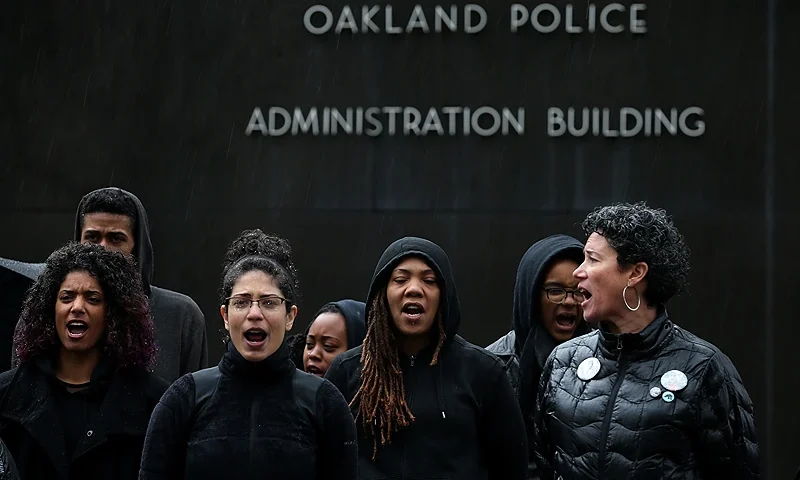 Protestors Chain Themselves To Oakland PD Headquarters OAKLAND, CA - DECEMBER 15: Protestors assemble in front of the Oakland police department headquarters during a demonstration over recent grand jury decisions in police-involved deaths on December 15, 2014 in Oakland, California. Over 200 hundred protestors blocked entrances to the Oakland police department and adjacent streets during a demonstration against recent grand jury decisions in New York and Missouri to not charge white police officers with the deaths of black men. Dozens were arrested. (Photo by Justin Sullivan/Getty Images)