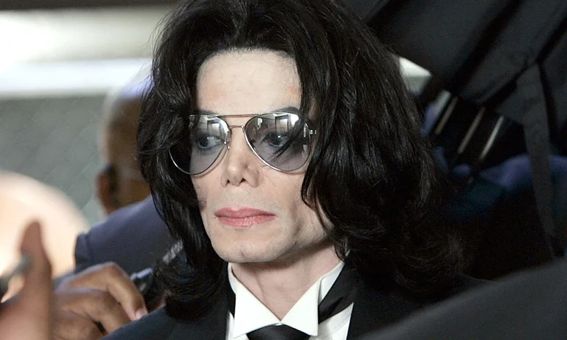 SANTA MARIA, CA - JUNE 13: Michael Jackson prepares to enter the Santa Barbara County Superior Court to hear the verdict read in his child molestation case June 13, 2005 in Santa Maria, California. After seven days of deliberation the jury has reached a not guilty verdict on all 10 counts in the trial against Michael Jackson. Jackson was charged in a 10-count indictment with molesting a boy, plying him with liquor and conspiring to commit child abduction, false imprisonment and extortion. He pleaded innocent. (Photo by Kevork Djansezian-Pool/Getty Images)