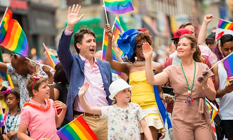 Prime Minister Justin Trudeau waves to the crowd as he, his wife Sophie Gregoire Trudeau and their children Xavier and Ella-Grace march in the Pride Parade in Toronto, June 25, 2017. / AFP PHOTO / GEOFF ROBINS (Photo credit should read GEOFF ROBINS/AFP via Getty Images)