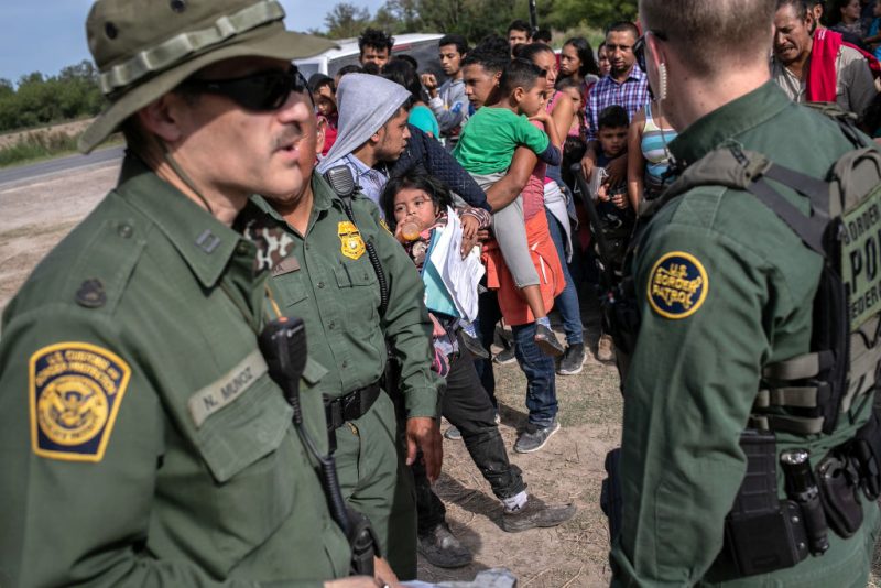 LOS EBANOS, TEXAS - JULY 02: U.S. Border Patrol agents watch over immigrants after taking them into custody on July 02, 2019 in Los Ebanos, Texas. Hundreds of immigrants, most from Central America, turned themselves in to border agents after rafting across the Rio Grande from Mexico to seek political asylum in the United States. (Photo by John Moore/Getty Images)