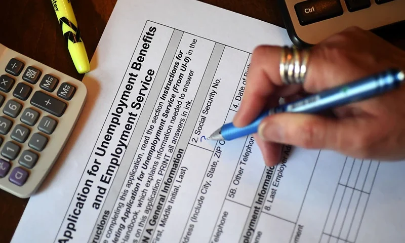 In this photo illustration, a person files an application for unemployment benefits on April 16, 2020, in Arlington, Virginia. - The government reported Thursday that another 5.2 million US workers filed for unemployment benefits, taking the four-week total to 22 million, a staggering figure in a downturn that economists say presents the country with its most severe outlook since the Great Depression of the 1930s. (Photo by Olivier DOULIERY / AFP) (Photo by OLIVIER DOULIERY/AFP via Getty Images)