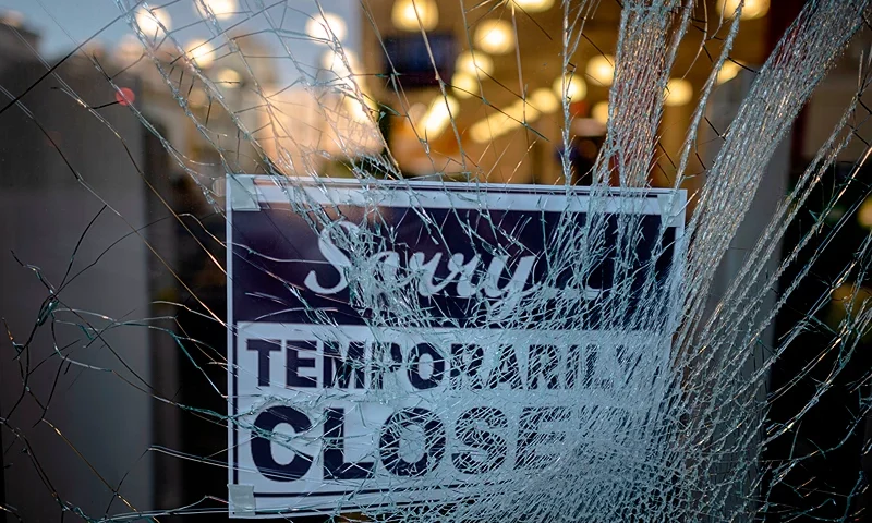 US-POLITICS-RACE-UNREST A sign reading "sorry temporarily closed" is seen behind a shattered glass of a storefront after a night of protest over the death of African-American man George Floyd in Minneapolis on June 1, 2020 in Lower Manhattan in New York City. - Thousands of National Guard troops patrolled major US cities after five consecutive nights of protests over racism and police brutality that boiled over into arson and looting, sending shock waves through the country. The death Monday of an unarmed black man, George Floyd, at the hands of police in Minneapolis ignited this latest wave of outrage in the US over law enforcement's repeated use of lethal force against African Americans -- this one like others before captured on cellphone video. (Photo by Johannes EISELE / AFP) (Photo by JOHANNES EISELE/AFP via Getty Images)