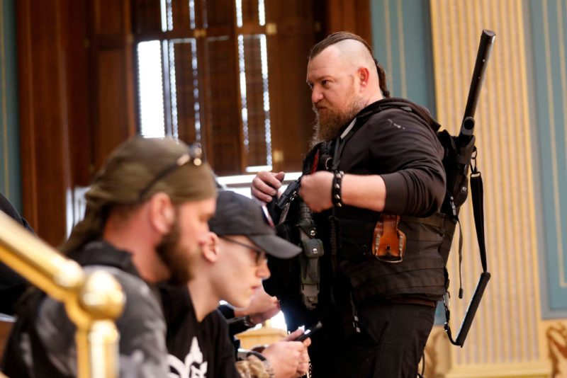 William Null (R) stands in the gallery of the Michigan Senate Chamber during the American Patriot Rally, organized by Michigan United for Liberty, to demand the reopening of businesses on the steps of the Michigan State Capitol in Lansing, Michigan, on April 30, 2020. Others are unidentified. - Thirteen men, including members of two right-wing militias, have been arrested for plotting to kidnap Michigan Governor Gretchen Whitmer and "instigate a civil war", Michigan Attorney General Dana Nessel announced on October 8, 2020. The Nulls were charged for their alleged roles in the plot to kidnap Whitmer, according to the FBI. The brothers are charged with providing support for terroristic acts and felony weapons charges. (Photo by JEFF KOWALSKY / AFP) (Photo by JEFF KOWALSKY/AFP via Getty Images)