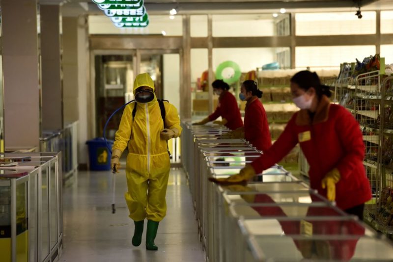 TOPSHOT - Employees spray disinfectant and wipe surfaces as part of preventative measures against the Covid-19 coronavirus at the Pyongyang Children's Department Store in Pyongyang on March 18, 2022. (Photo by KIM Won Jin / AFP) (Photo by KIM WON JIN/AFP via Getty Images)