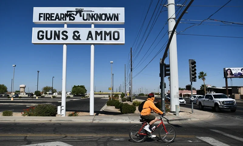 TOPSHOT-US-WEAPONRY TOPSHOT - The silhouette AR-15 style rifle is displayed on signage for the Firearms Unknown Guns & Ammo gun store, in Yuma, Arizona on June 2, 2022. - US President Joe Biden on June 2, 2022 urged lawmakers to ban privately owned assault weapons and high capacity magazines in order to curb the mass shootings plaguing the country. (Photo by Patrick T. FALLON / AFP) (Photo by PATRICK T. FALLON/AFP via Getty Images)