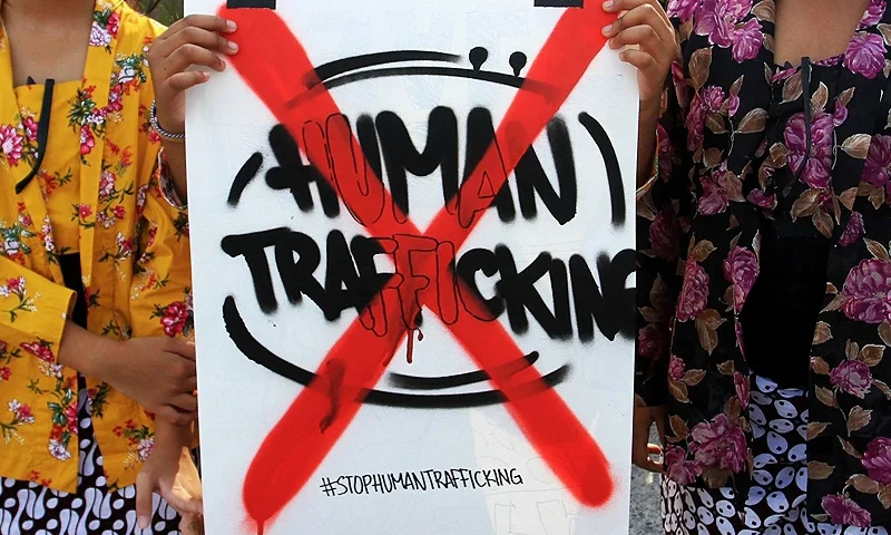 INDONESIA-CRIME-TRAFFICKING-PROTEST Youths pose with a placard during a protest to mark the World Day against Trafficking in Persons, in Yogyakarta on July 31, 2022. (Photo by DEVI RAHMAN / AFP) (Photo by DEVI RAHMAN/AFP via Getty Images)