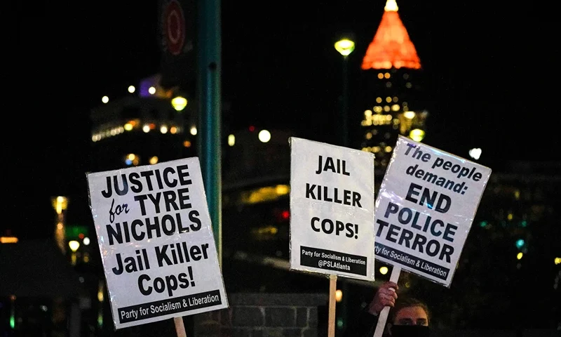 US-POLICE-JUSTICE-DEMO Protesters holds placards as they rally against the fatal police assault of Tyre Nichols, in Atlanta, Georgia, on January 27, 2023. - The US city of Memphis released January 27, 2023 graphic video footage depicting the fatal police assault of a 29-year-old Black man, as cities nationwide braced for a night of protests against police brutality. Five Memphis officers, also all Black, were charged with second-degree murder in the beating of Tyre Nichols, who died in hospital on January 10 three days after being stopped on suspicion of reckless driving. (Photo by CHENEY ORR / AFP) (Photo by CHENEY ORR/AFP via Getty Images)
