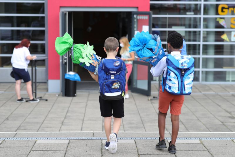 OBERPLEIS, GERMANY - AUGUST 13: First graders arrive with goodie bags for their first introductory day to school during the coronavirus pandemic on August 13, 2020 in Oberpleis near Bonn, Germany. Classes at schools across Germany are beginning this month with face mask requirements varying by state. Coronavirus infection rates are climbing again in Germany, from an average of 400 new cases per day about two weeks ago up to over 1,300 in recent days, according to the Robert Koch Institute. (Photo by Andreas Rentz/Getty Images)