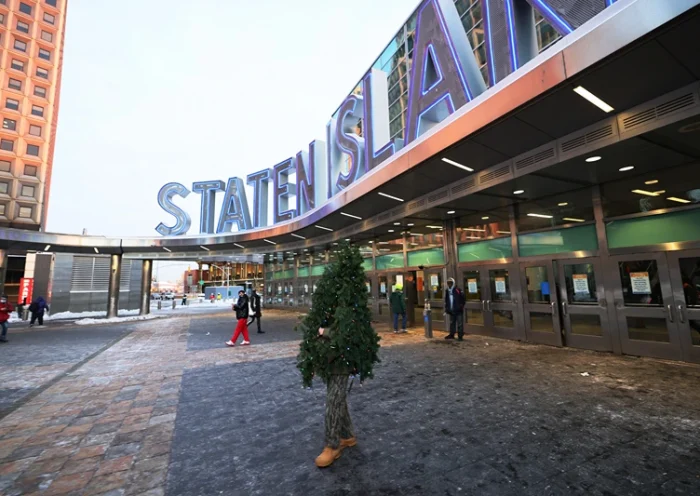 NEW YORK, NEW YORK - DECEMBER 18: Tommy Liberto walks out of the Staten Island ferry terminal after arriving in NYC wearing a Christmas tree costume on December 18, 2020 in New York City. Liberto has traveled to New York City and Los Angeles from Maryland for the past six years in his Christmas tree costume to help spread joy throughout the holidays. (Photo by Michael M. Santiago/Getty Images)