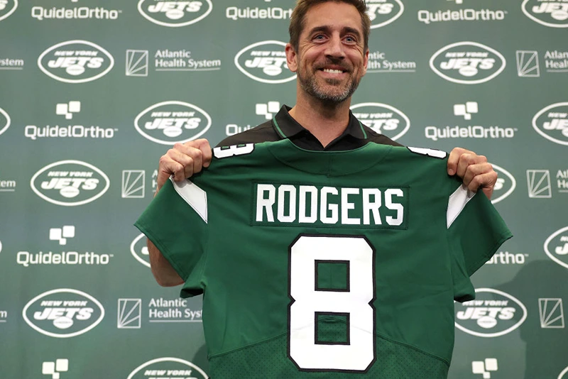 FLORHAM PARK, NEW JERSEY - APRIL 26: New York Jets quarterback Aaron Rodgers poses with a jersey during an introductory press conference at Atlantic Health Jets Training Center on April 26, 2023 in Florham Park, New Jersey. (Photo by Elsa/Getty Images)