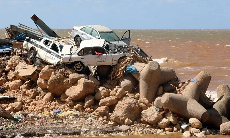 LIBYA-STORM-FLOOD Cars are piled up atop wave breakers and the rubble of a building destroyed in flash floods after the Mediterranean storm "Daniel" hit Libya's eastern city of Derna, on September 14, 2023. A global aid effort for Libya gathered pace on September 14 after a tsunami-sized flash flood killed at least 4,000 people, with thousands more missing, a death toll the UN blamed in part on the legacy of years of war and chaos. (Photo by Abdullah DOMA / AFP) (Photo by ABDULLAH DOMA/AFP via Getty Images)