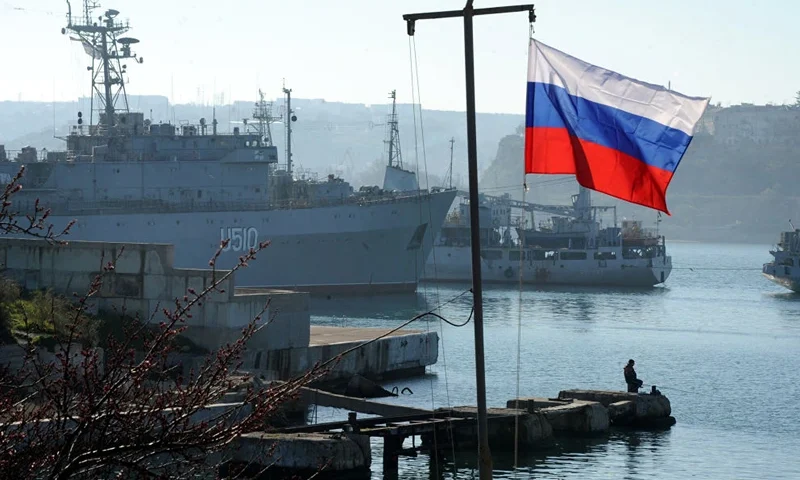 TOPSHOT - The Russian flag waves in front of the Ukrainian military ship the Slavutich moored in the bay of Sevastopol on March 22, 2014. About 200 pro-Russian protesters on March 22 stormed a Ukrainian air force base in western Ukraine, AFP correspondents saw. The unarmed crowd broke through to the base in the town of Novofedorivka and started smashing windows as Ukrainian servicemen barricaded themselves inside buildings and threw smoke bombs at the intruders from the roof. AFP PHOTO/ VIKTOR DRACHEV (Photo by VIKTOR DRACHEV / AFP) (Photo by VIKTOR DRACHEV/AFP via Getty Images)