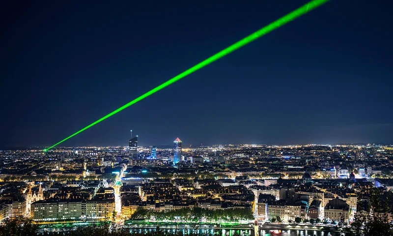 TOPSHOT-FRANCE-SCIENCE-LIGHT TOPSHOT - A green laser ray is emitted above Lyon to calculate the variations of light speed in the atmosphere on September 24, 2015. AFP PHOTO / JEFF PACHOUD (Photo by JEFF PACHOUD / AFP) (Photo by JEFF PACHOUD/AFP via Getty Images)