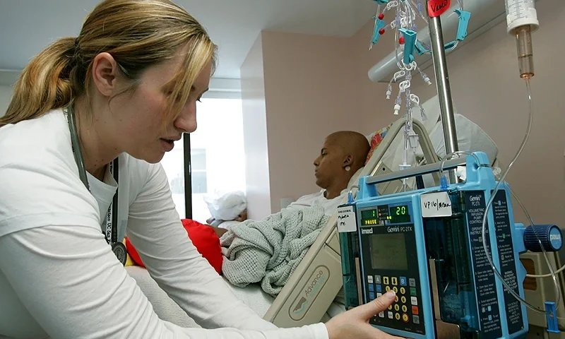 SAN FRANCISCO - AUGUST 18: Registered nurse Autumn Small adjusts an IV drip machine for eighteen-year-old cancer patient Patrick McGill as he receives treatment for a rare form of cancer at the UCSF Comprehensive Cancer Center Childrens Hospital August 18, 2005 in San Francisco, California. The UCSF Comprehensive Cancer Center continues to use the latest research and technology to battle cancer and was recently rated 16th best cancer center in the nation by US News and World Report. (Photo by Justin Sullivan/Getty Images)