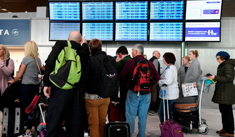 Travellers look at screens displaying departures flights at Paris-Charles-de-Gaulle airport after a US 30-day ban on travel from Europe due to the COVID-19 spread in Roissy-en-France on March 12, 2020. - US President Donald Trump announced on March 11, 2020 a shock 30-day ban on travel from mainland Europe over the coronavirus pandemic that has sparked unprecedented lockdowns, widespread panic and another financial market meltdown. (Photo by Bertrand GUAY / AFP) (Photo by BERTRAND GUAY/AFP via Getty Images)