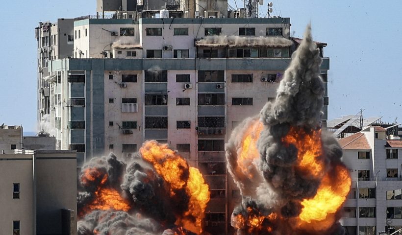 TOPSHOT - A ball of fire erupts from the Jala Tower as it is destroyed in an Israeli airstrike in Gaza City, controlled by the Palestinian Hamas movement, on May 15, 2021. - Israeli air strikes pounded the Gaza Strip, killing 10 members of an extended family and demolishing a key media building, while Palestinian militants launched rockets in return amid violence in the West Bank. Israel's air force targeted the 13-floor Jala Tower housing Qatar-based Al-Jazeera television and the Associated Press news agency. (Photo by Mahmud Hams / AFP) (Photo by MAHMUD HAMS/AFP via Getty Images)