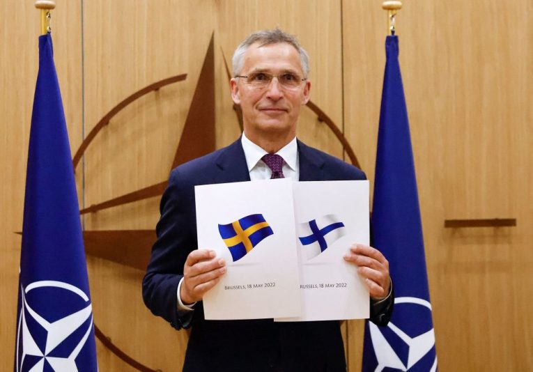 TOPSHOT - NATO Secretary-General Jens Stoltenberg poses with application documents presented by Finland's Ambassador to NATO Klaus Korhonen and Sweden's Ambassador to NATO Axel Wernhoff during a ceremony to mark Sweden's and Finland's application for membership in Brussels, on May 18, 2022. - Finland and Sweden submitted their applications for NATO membership on May 18, 2022 and consultations were underway between the Allies to lift Turkey's opposition to the integration of the two Nordic countries into the Alliance. (Photo by JOHANNA GERON / POOL / AFP) (Photo by JOHANNA GERON/POOL/AFP via Getty Images)