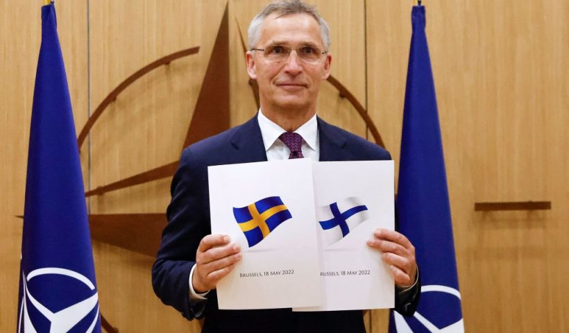 TOPSHOT - NATO Secretary-General Jens Stoltenberg poses with application documents presented by Finland's Ambassador to NATO Klaus Korhonen and Sweden's Ambassador to NATO Axel Wernhoff during a ceremony to mark Sweden's and Finland's application for membership in Brussels, on May 18, 2022. - Finland and Sweden submitted their applications for NATO membership on May 18, 2022 and consultations were underway between the Allies to lift Turkey's opposition to the integration of the two Nordic countries into the Alliance. (Photo by JOHANNA GERON / POOL / AFP) (Photo by JOHANNA GERON/POOL/AFP via Getty Images)