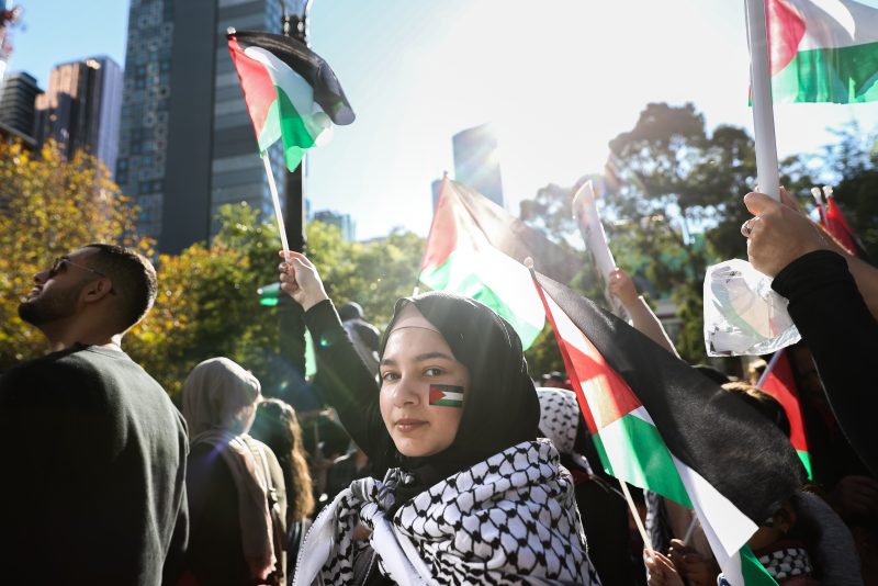 MELBOURNE, AUSTRALIA - MAY 22: A Pro-Palestinian protestor with the Palestinian flag painted on her face is seen waving a Palestinian flag during a Rally on May 22, 2021 in Melbourne, Australia. Rallies were organised across Australia to protest against the recent violence in Israel and the Gaza strip. A ceasefire between Israel and Hamas in Gaza started on Friday, following 11 days of rocket attacks. (Photo by Asanka Ratnayake/Getty Images)