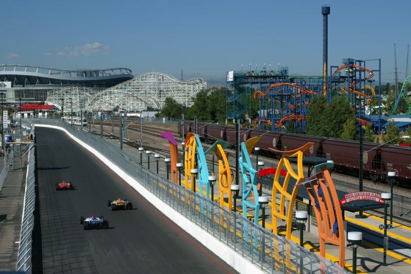 DENVER, CO - AUGUST 30: Team Motorola driver Michael Andretti drives his Honda Lola in front of a train stop and the Six Flags Elitch Gardens amusement park during practice for the Shell Grand Prix of Denver, round 14 of the CART (Championship Auto Racing Teams) Fed Ex Championship Series in Denver, Colorado. (Photo by Robert Laberge/Getty Images).