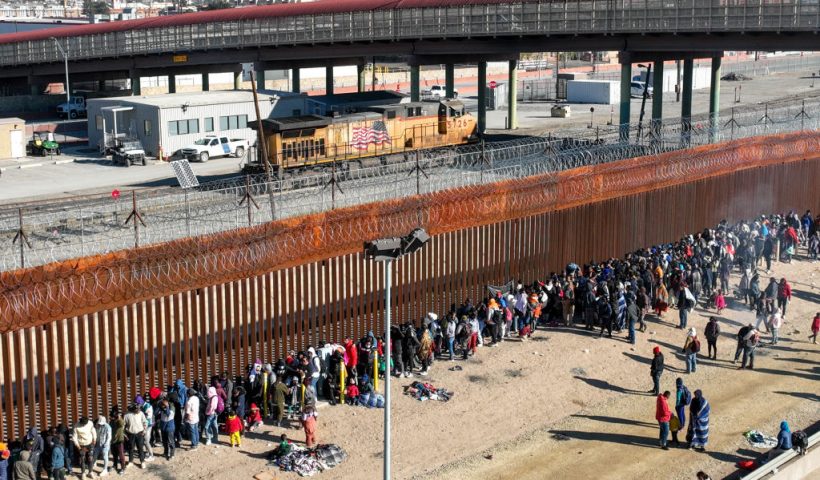 CIUDAD JUAREZ, MEXICO - DECEMBER 21: As seen from an aerial view, migrants line up along the U.S. Mexico border fence to apply for asylum in the United States on December 21, 2022 as viewed from Ciudad Juarez, Mexico. Texas Governor Greg Abbott ordered 400 troops to the U.S.-Mexico border in El Paso, which is under a state of emergency due to a surge of migrants crossing from Mexico into the city. Border officials expect an even larger migrant surge at the border if the pandemic era Title 42 regulation is lifted. (Photo by John Moore/Getty Images)