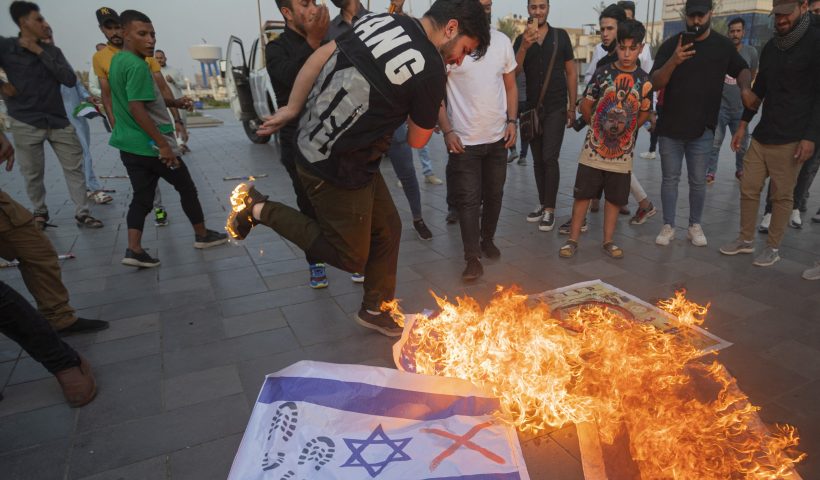 TOPSHOT - Iraqis burn Israeli flags during a rally held in central Baghdad on October 7, 2023 in support of the Palestinians, after Hamas militants launched a deadly air, land and sea assault into Israel from the Gaza Strip. (Photo by Murtadha Ridha / AFP) (Photo by MURTADHA RIDHA/AFP via Getty Images)