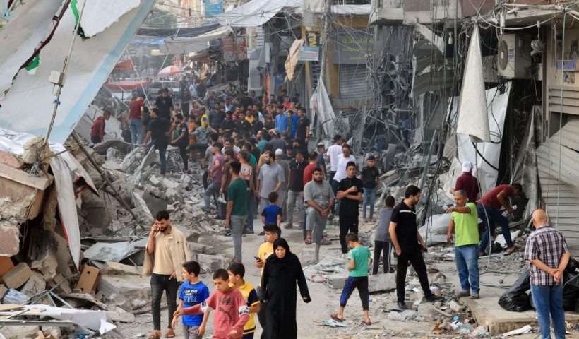 TOPSHOT - Palestinians walk amid the rubble of destroyed and damaged building in the heavily bombarded city center of Khan Yunis in the southern Gaza Strip following overnight Israeli shelling, on October 10, 2023. Israel pounded Hamas targets in Gaza on October 10 and said the bodies of 1,500 Islamist militants were found in southern towns recaptured by the army in gruelling battles near the Palestinian enclave. (Photo by SAID KHATIB / AFP) (Photo by SAID KHATIB/AFP via Getty Images)