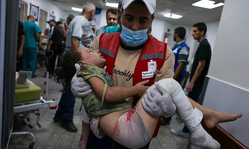 TOPSHOT - An emergency responder carries a wounded child in a hospital following Israeli airstrikes in Rafah, southern Gaza Strip, on October 13, 2023. Israel has called for the immediate relocation of 1.1 million people in Gaza amid its massive bombardment in retaliation for Hamas's attacks, with the United Nations warning of "devastating" consequences. (Photo by SAID KHATIB / AFP) (Photo by SAID KHATIB/AFP via Getty Images)