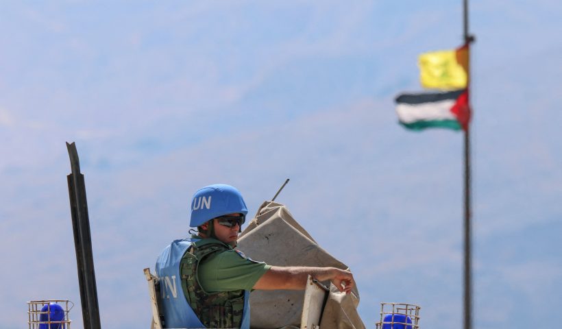 LEBANON-ISRAEL-PALESTINIAN-UN-CONFLICT The Palestinian flag and the flag of Hezbollah wave in the wind on a pole as peacekeepers from the United Nations Interim Force in Lebanon (UNIFIL) patrol the border area between Lebanon and Israel on Hamames hill in the Khiyam area of southern Lebanon, on October 13, 2023. Israel shelled a border region in southern Lebanon, two Lebanese security sources said, after a blast occurred on the border fence, according to the Israeli army. (Photo by Joseph EID / AFP) (Photo by JOSEPH EID/AFP via Getty Images)
